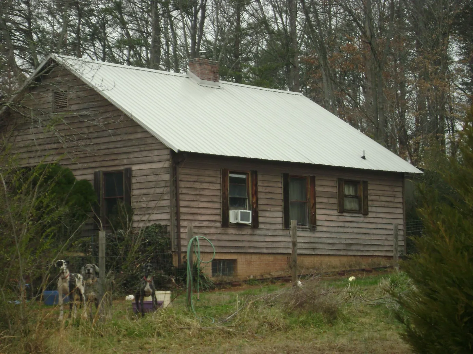 White metal roof on an old wood sided farmhouse, from a Metal Roof Installation job in Canton